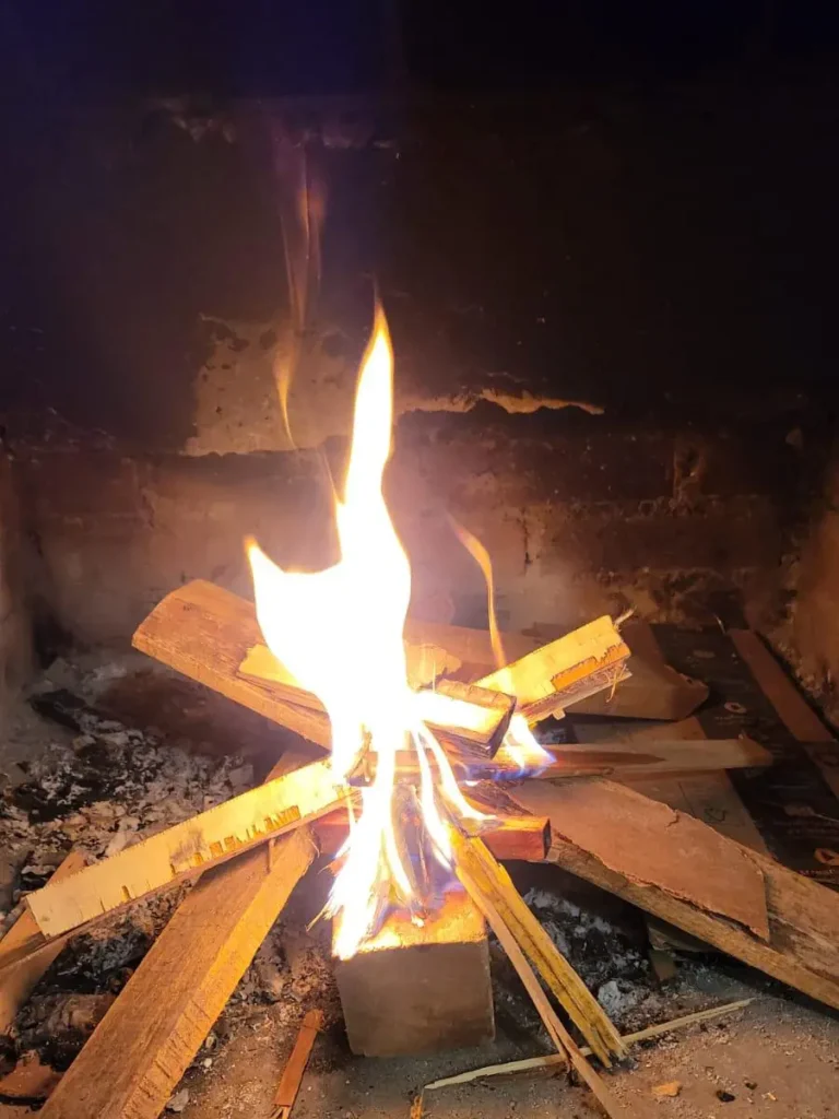 Fuego ardiente en un hogar tradicional, evocando los orígenes de la humanidad y la calidez del progreso